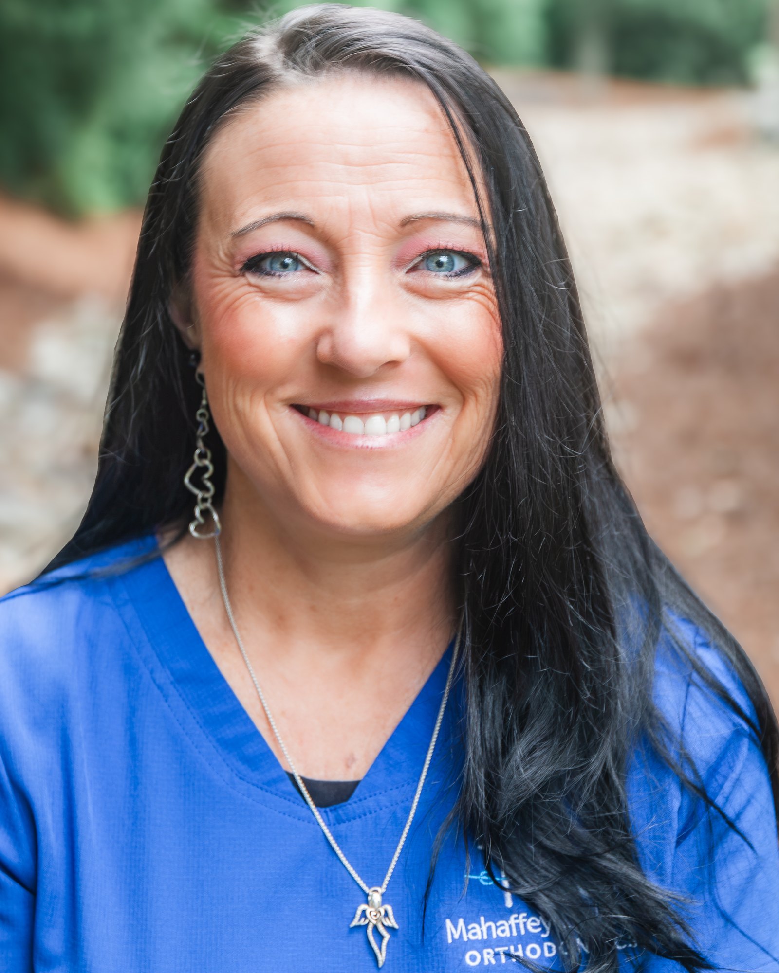 Crystal, Clinical Assistant at Mahaffey Linkous Orthodontics, smiling outdoors in a branded blue polo