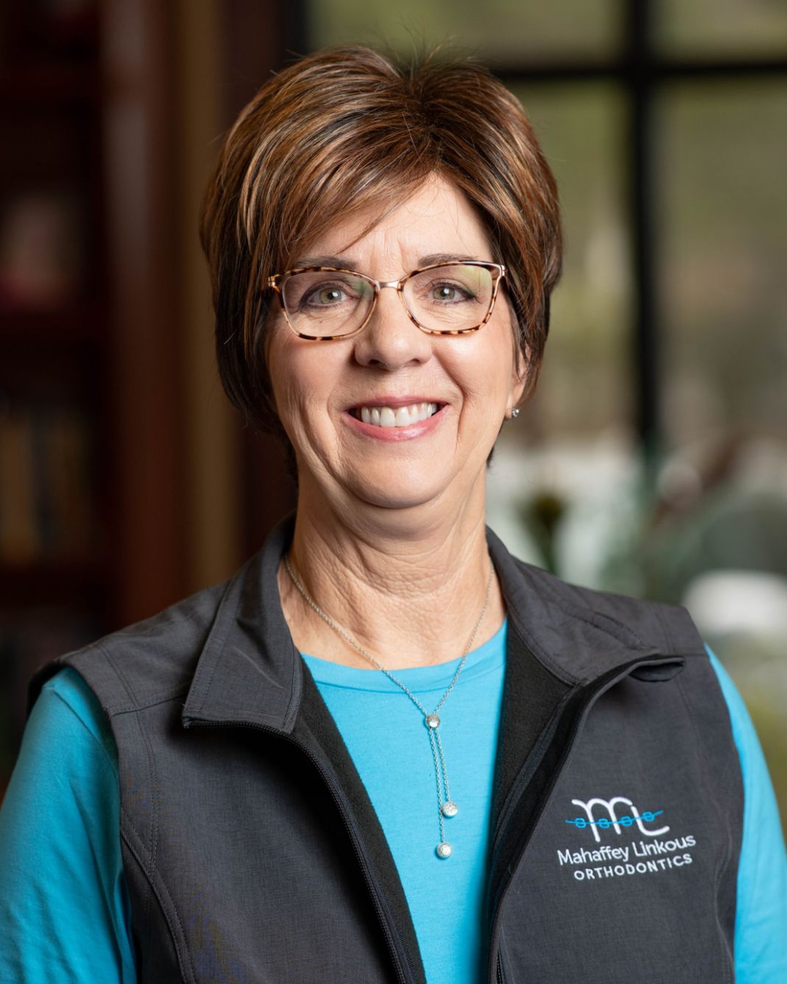 Dana, Financial Coordinator at Mahaffey Linkous Orthodontics, smiling in a branded vest