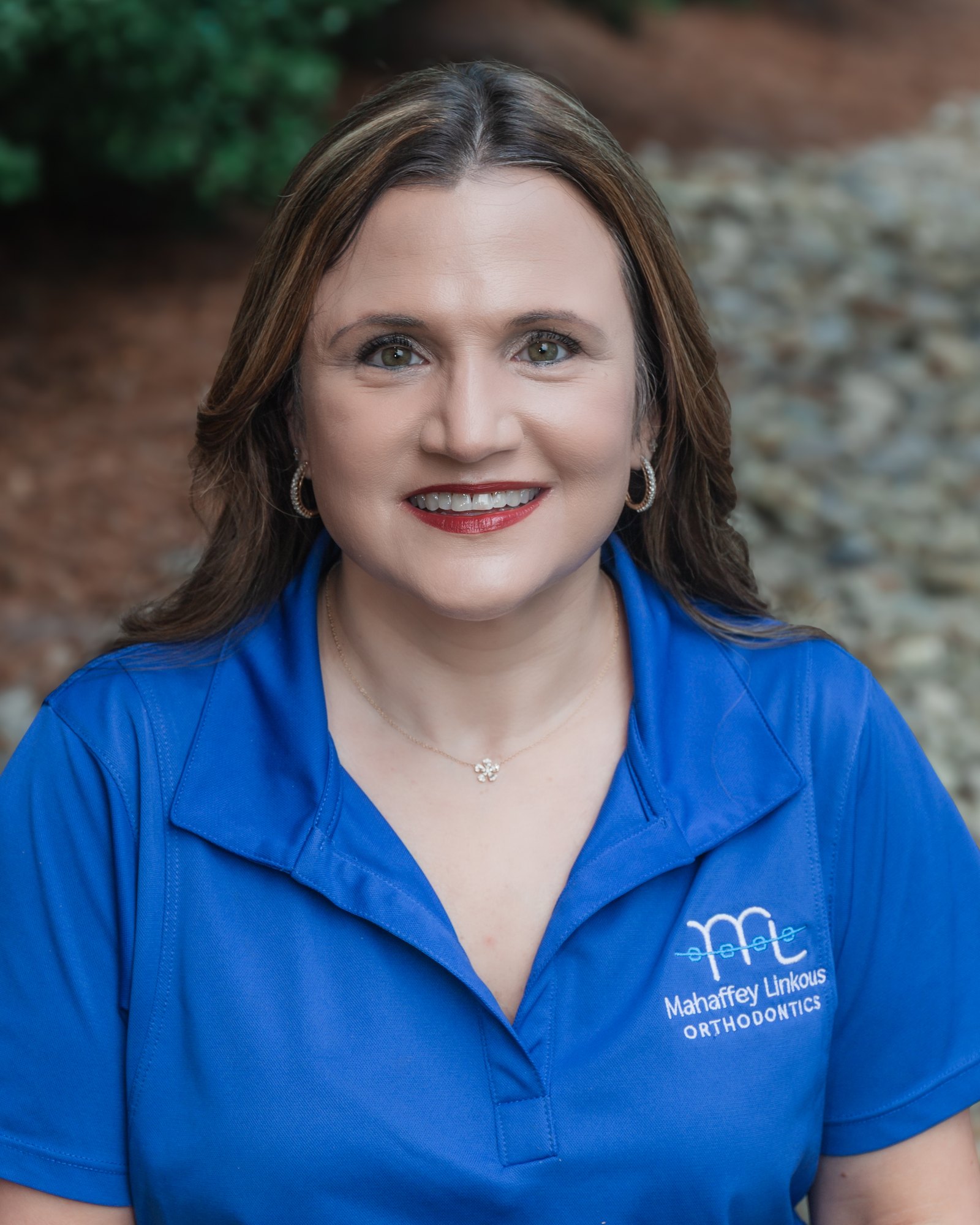Jacelyn, HR Manager at Mahaffey Linkous Orthodontics, smiling outdoors in a branded blue polo