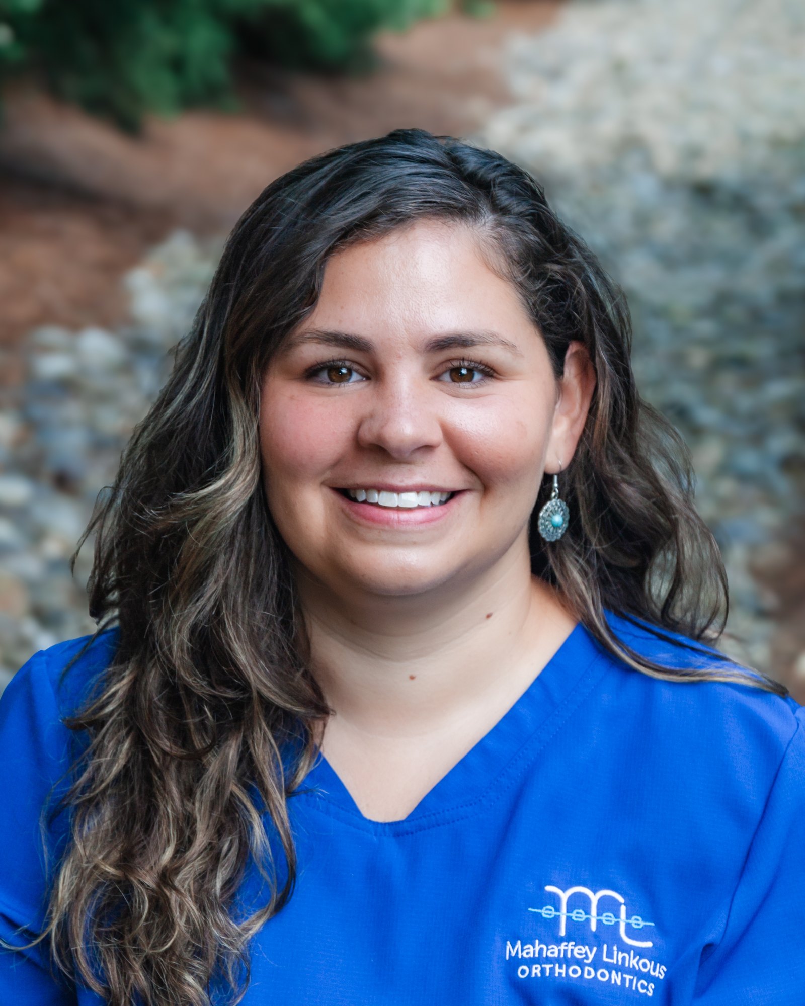 Kayla, Clinical Assistant at Mahaffey Linkous Orthodontics, smiling outdoors in a branded blue polo