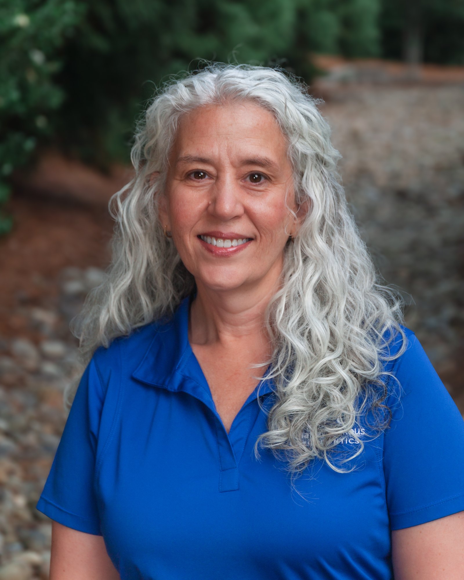 Tammy, Treatment Coordinator at Mahaffey Linkous Orthodontics, smiling outdoors in a branded blue polo