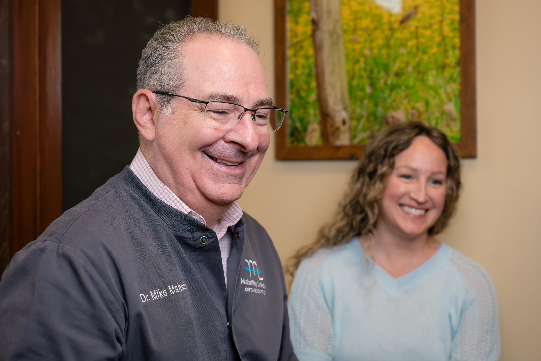 Dr. Mike Mahaffey, Peachtree City orthodontist at Mahaffey Linkous Orthodontics, laughing with a smiling adult patient during her visit to the Peachtree City, GA office