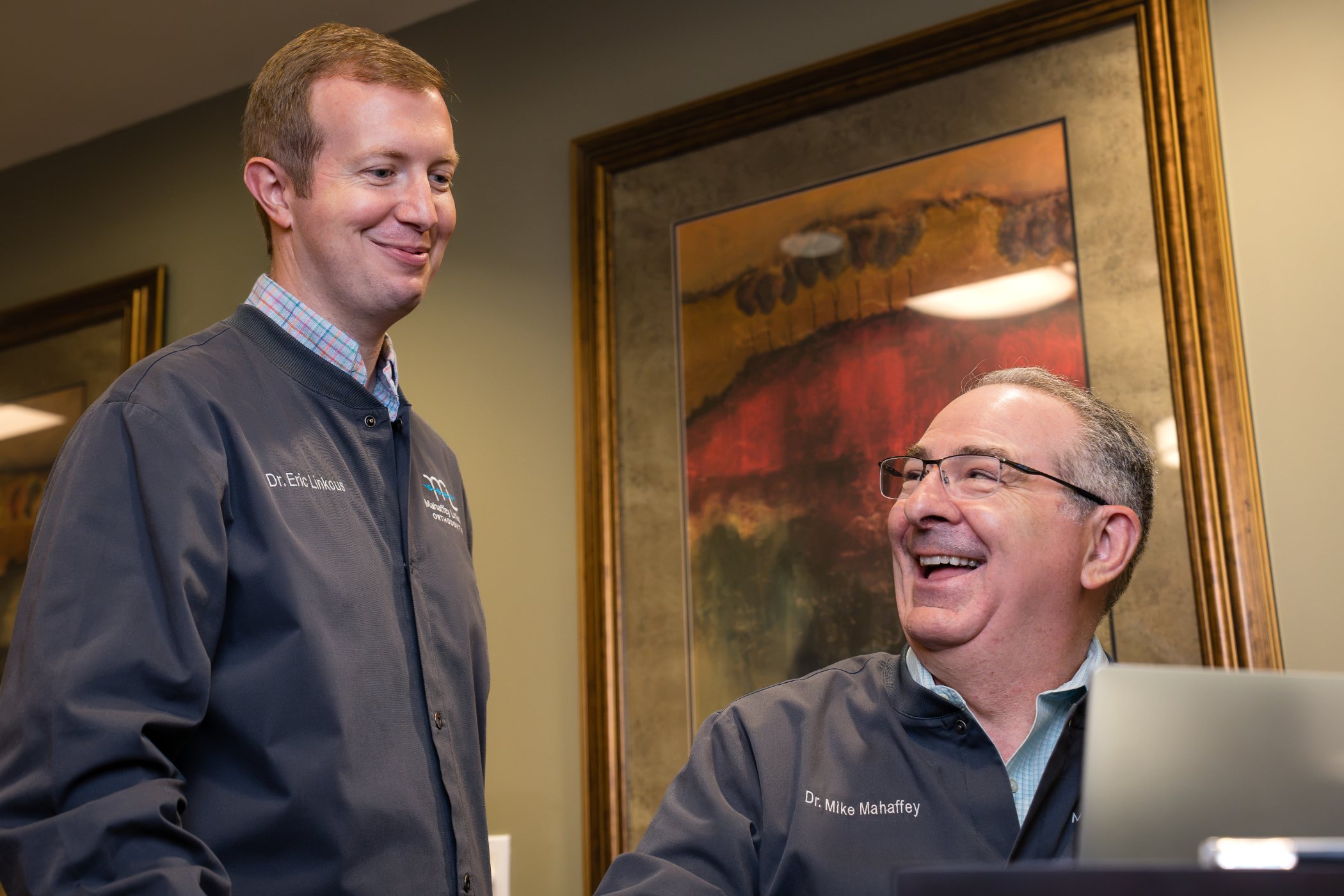 Orthodontists Dr. Eric Linkous and Dr. Mike Mahaffey sharing a laugh in the office at Mahaffey Linkous Orthodontics in Peachtree City, GA